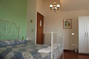 1 dormitorio con cama y lámpara de araña en Mimì e Cocò Country House, en Ascoli Piceno