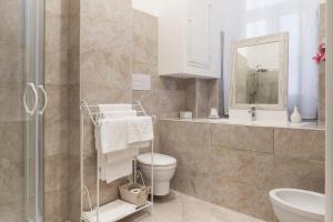 een badkamer met een toilet, een wastafel en een spiegel bij Blunotte Suite in Potenza