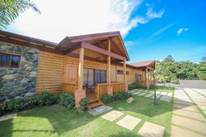 a log cabin with a pathway in front of it at Carmen Hotel & Villas in Jarabacoa