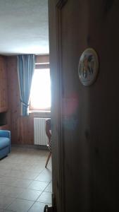 sala de estar con ventana y sofá azul en Chalet Le Betulle en Santa Caterina Valfurva