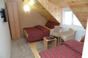 um quarto no sótão com 2 camas e uma escada em Apartments Radović em Kolašin