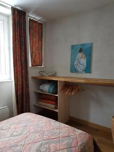a bedroom with a bed and a painting on the wall at Appartement Cap Horn in Le Mont-Dore
