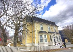 uma casa amarela com uma cerca branca à frente. em The Rendell Shea Manor em St. John's