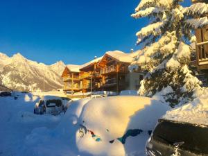 a snow covered parking lot in front of a lodge at L'Eyssaben Appartement de grand standing à Serre-Chevalier in Le Monêtier-les-Bains