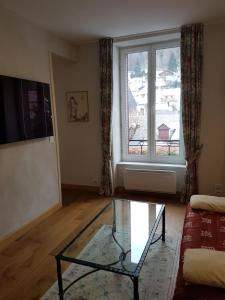 a living room with a glass table and a window at Appartement Cap Horn in Le Mont-Dore