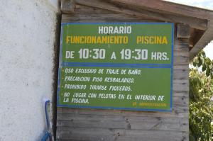 una señal que está al lado de un edificio en Cabañas Hecmar, en Pichilemu
