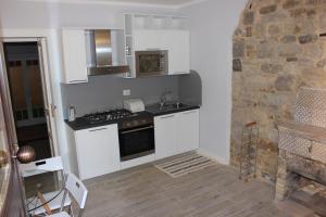 - une cuisine avec des appareils blancs et un mur en pierre dans l'établissement Borgo Dauno-Il Rifugio, à Volturara Appula