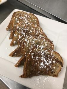 two pieces of bread on a plate with powdered sugar at Lolo Hot Springs in Lolo Hot Springs