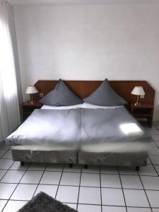 a large bed with white sheets and pillows in a bedroom at Lipmann am boll in Hamm