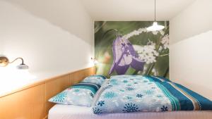 1 cama con almohadas azules y blancas y una pintura en Apartment Sonnwies, en Verano