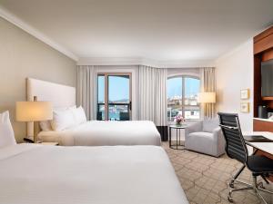 ビクトリアにあるホテル グランド パシフィックのベッド2台とデスクが備わるホテルルームです。