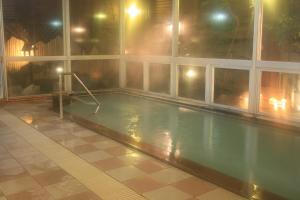 una piscina en un edificio por la noche en Hotel Yuzan, en Chikuma