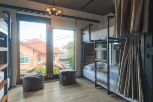 33 Poshtel في شيانغ ماي: غرفة نوم مع سرير بطابقين ونوافذ كبيرة