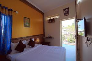 a bedroom with a white bed and a window at Gems 9 Airport Hotel in Nedumbassery