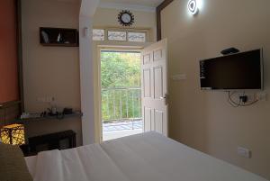a bedroom with a bed and a tv and a window at Gems 9 Airport Hotel in Nedumbassery