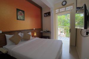 a bedroom with a large white bed and a window at Gems 9 Airport Hotel in Nedumbassery
