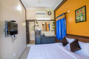 a bedroom with a white bed and a bathroom at Gems 9 Airport Hotel in Nedumbassery