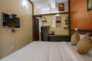 a bedroom with a large bed with a tv on the wall at Gems 9 Airport Hotel in Nedumbassery
