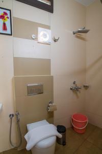 a bathroom with a toilet and a shower at Gems 9 Airport Hotel in Nedumbassery