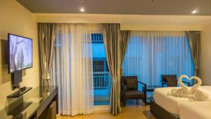Habitación de hotel con 1 dormitorio con cama y ventana en Unique Regency Pattaya, en Pattaya South