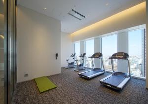 a gym with cardio equipment in a room with windows at Nagoya JR Gate Tower Hotel in Nagoya