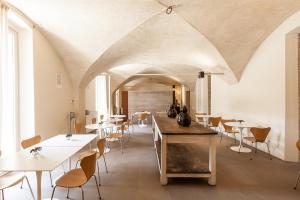 a dining room with white tables and chairs at Nun Assisi Relais & Spa Museum in Assisi