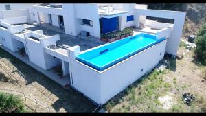 an aerial view of a white house with a swimming pool at B&B Blu Infinito in Villa San Giovanni