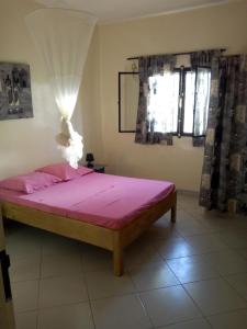 a bedroom with a bed with pink sheets and a window at La Somonoise in Somone