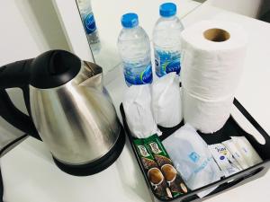 a tray with toilet paper and water bottles on a counter at Subrangsee Apartment in Chiang Rai