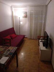 sala de estar con sofá rojo y mesa en Madrid Rent 4 en Madrid