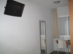a room with a flat screen tv on the wall at Hostal Ducal II in Gandía