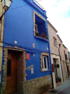 - un bâtiment bleu avec une fenêtre et un balcon dans l'établissement La Casassa, à Les Coves de Vinroma
