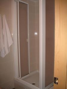 y baño con ducha y puerta de cristal. en Hostal Ducal II, en Gandía