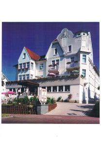 een groot wit gebouw met een bord ervoor bij Hotel Wildunger Hof mit Gemeinschaftsküche in Bad Wildungen