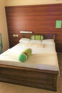 a bed with a wooden headboard and pillows on it at Winter Dream Holiday Bungalow Nuwara Eliya in Nuwara Eliya