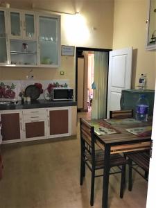 a kitchen with a table and a kitchen with a microwave at Winter Dream Holiday Bungalow Nuwara Eliya in Nuwara Eliya