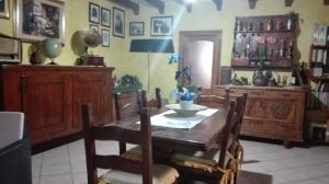 a dining room with a wooden table and chairs at B&b Su Acu in Dorgali