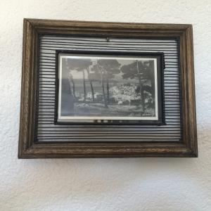 a picture in a wooden frame hanging on a wall at Apartments Atila in Mali Lošinj