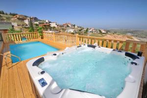 a hot tub on a deck next to a swimming pool at Family Villa in Safed