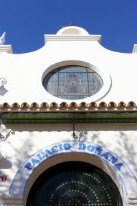 a building with a window above the entrance to a casino at Palacio Doñana , Rural & Luxury in El Rocío