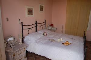 a bedroom with a white bed with fruit on it at La Papaya in Marina di Pisa