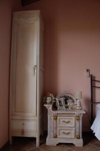 a bedroom with a white cabinet next to a bed at La Papaya in Marina di Pisa
