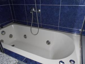 e bagno con piastrelle blu, vasca e doccia. di Mi Capricho a Barra de Maldonado Altre 14 foto