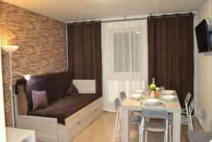 ein Wohnzimmer mit einem Sofa und einem Esstisch in der Unterkunft Apartmány Rysí skála in Loučná nad Desnou