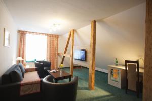 a living room with a couch and a bed at Hotel Doberaner Hof in Bad Doberan