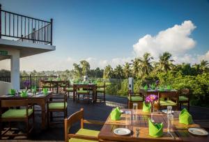 a restaurant with tables and chairs on a deck at Arena Hotel in Beruwala