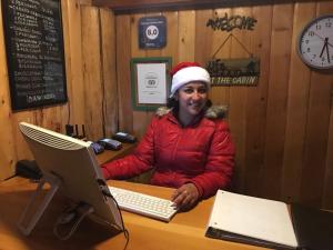 a man in a santa hat sitting at a desk with a computer at Cabañas El Estribo Hotel in Valle de Bravo
