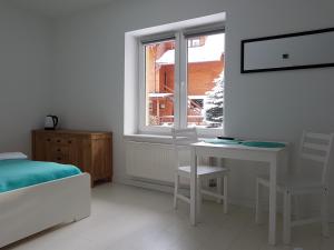 a bedroom with a bed and a table and a window at W Chmurach in Karpacz