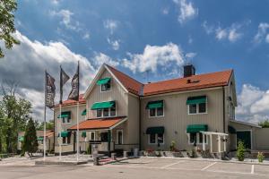 a building with two flags in a parking lot at Skultuna Hotell & Konferens in Skultuna