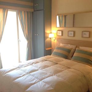 a bedroom with a large white bed with a window at bord de mer in Sint-Idesbald